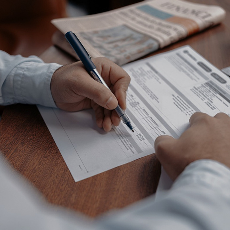 Hand holding a pen filling out a form